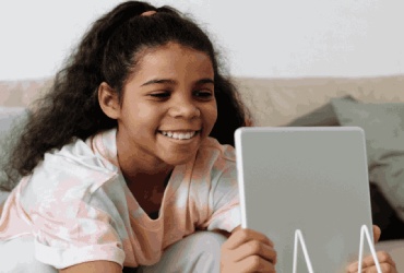 Niña estudiando español en línea en vivo en su tablet en Berlin